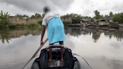 Une élève ramant pour rejoindre la rive où l’attendent d’autres élèves.