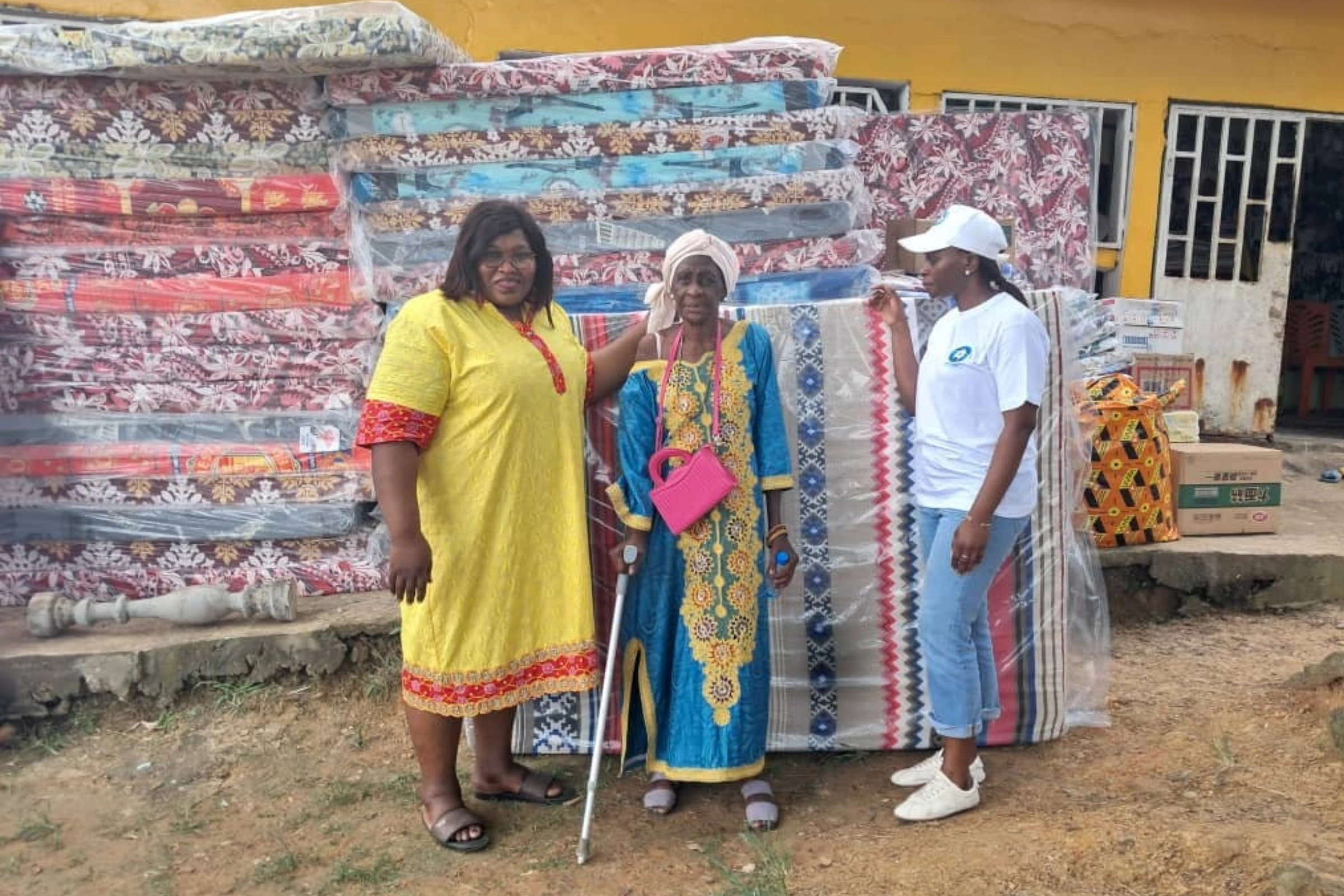 La vice-présidente de l’association Tabitha Hortense Kothor (casquette), la responsable de l’orphelinat, Moussounda Darly (robe jaune) remettant symboliquement le présent à une veuve.