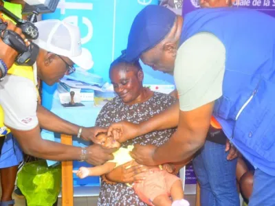 Un responsable sanitaire administrant une dose de vaccin à un bébé.