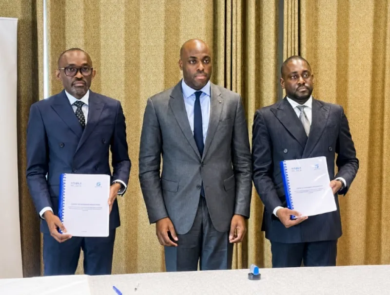 Les deux signataires entourés du ministre