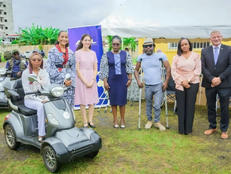 Les officiels ont posé avec une des bénéficiaires de scooters.