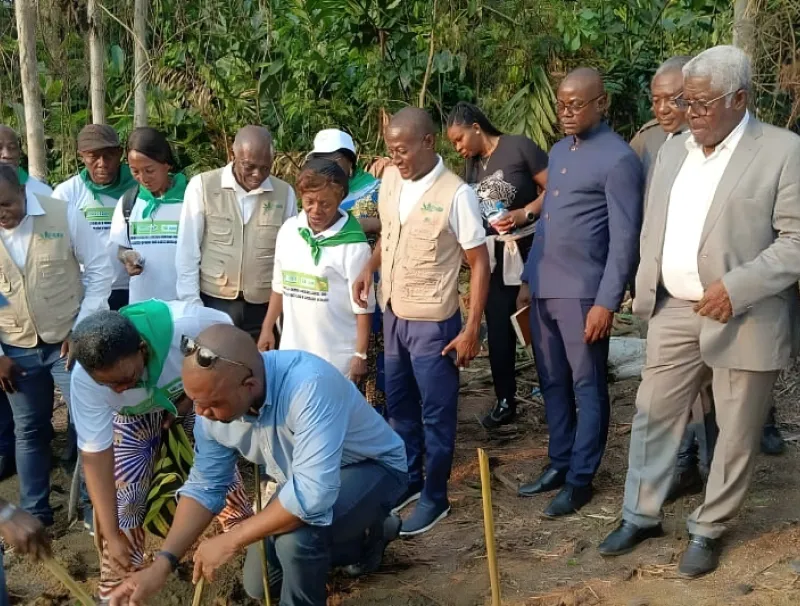 Le membre du gouvernement (accroupi) lançant symboliquement la culture du soja et du maïs jaune au village Nkoum-Yengui dans le Woleu