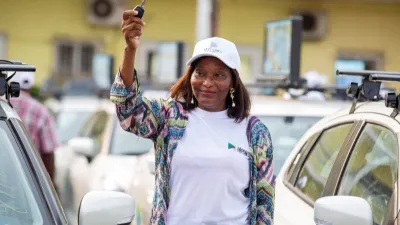 Une bénéficiaire devant son Taxi