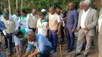 Le membre du gouvernement (accroupi) lançant symboliquement la culture du soja et du maïs jaune au village Nkoum-Yengui dans le Woleu