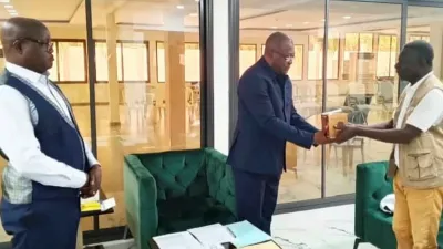 Le responsable local de lutte contre le VIH/Sida remet symboliquement un lot de préservatifs au gouverneur de province.